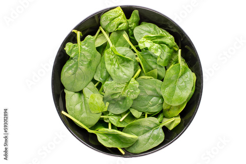 Fresh green spinach leaves in black ceramic plate isolated on white background, macro, top view.