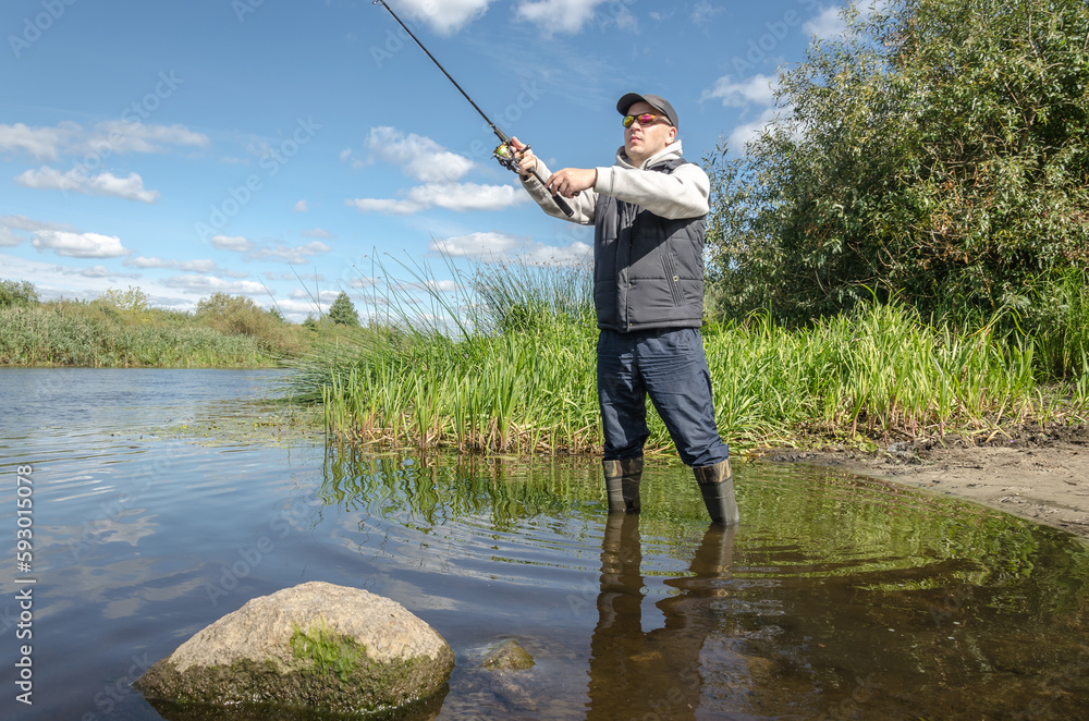 Man catching fish, pulling rod while fishing. Man catching fish, pulling rod while fishing.