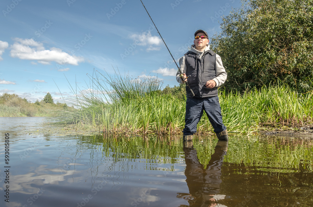 Fisherman in a hat on the river bank Fisherman in a hat on the river bank