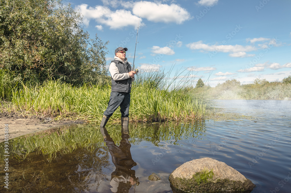 Man catching fish, pulling rod while fishing.