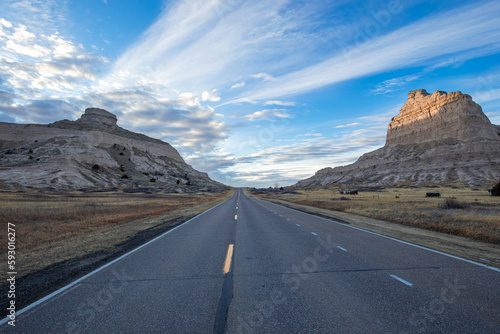 Oregon Trail Road through the Old Oregon Trail at sunset in Scotts Bluff National Monument Nebraska in winter with blue sky and clouds.
