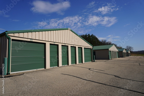 Green and white storage units are being used to hold rental property and belongings.