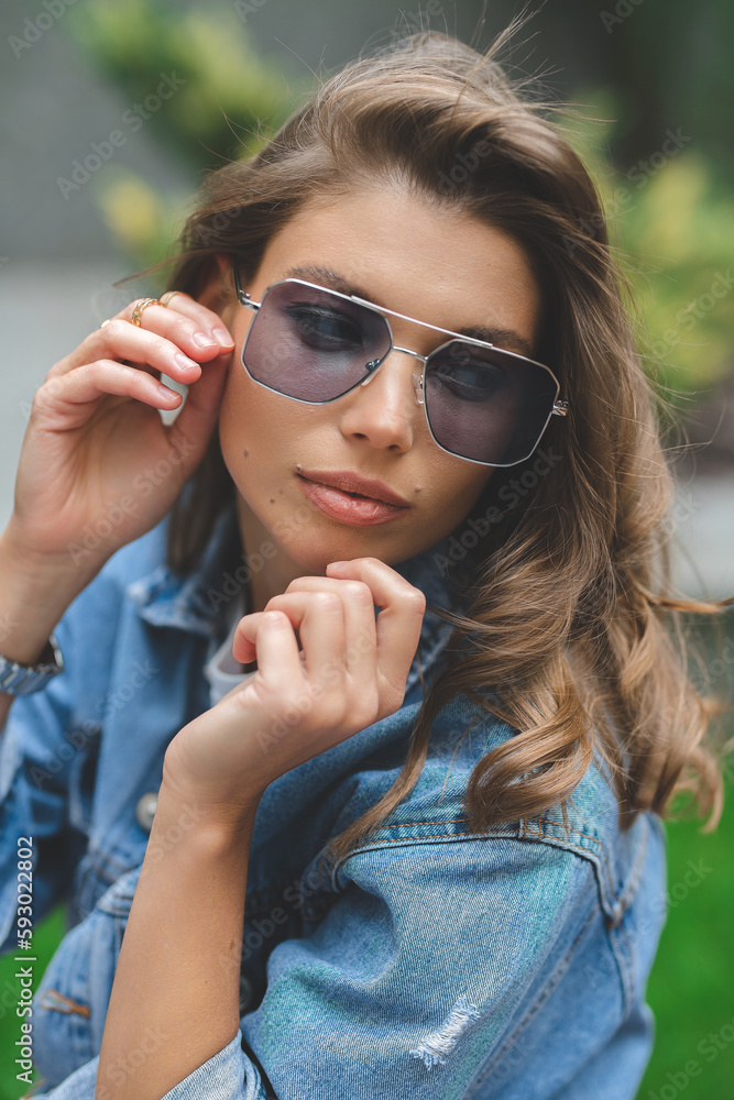 Hipster girl in clean white t-shirt and jeans posing against the background of buildings, minimalist urban clothing style Hipster girl in clean white t-shirt and jeans posing against the background of buildings, minimalist urban clothing style