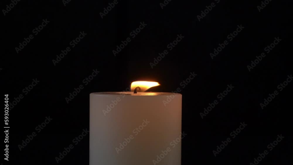 Close-up of a burning candle isolated with black background Close-up of a burning candle isolated with black background