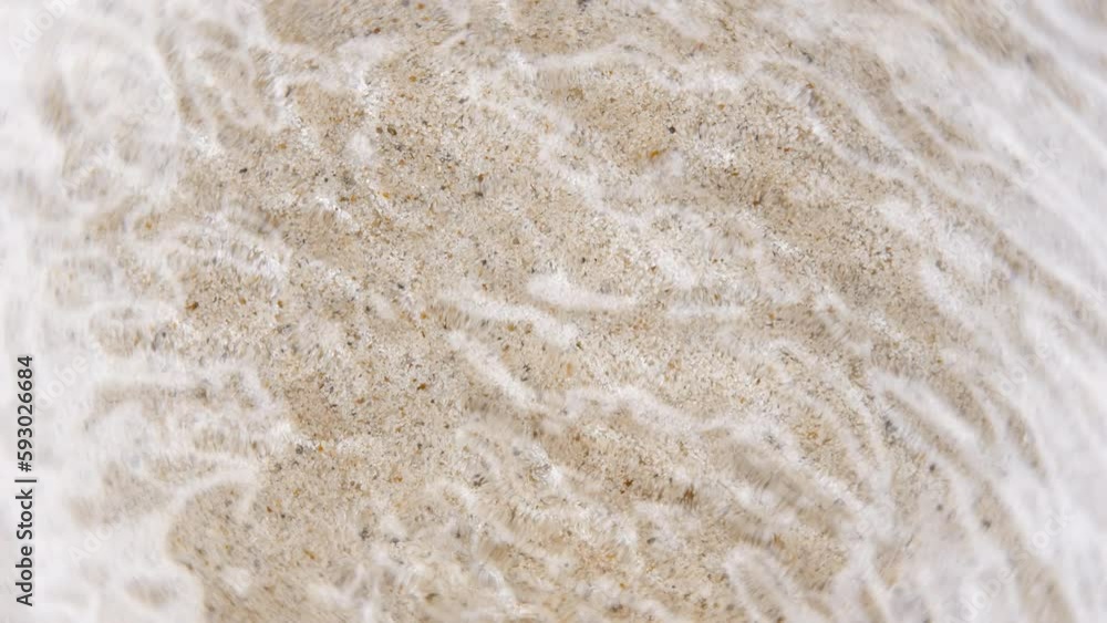Top down view seabed texture, sea floor beach sand ripple of water waves reflection. Yellow sandy river bottom surface summer background slow motion. Underwater seafloor close-up Top down view seabed texture, sea floor beach sand ripple of water waves reflection. Yellow sandy river bottom surface summer background slow motion. Underwater seafloor close-up