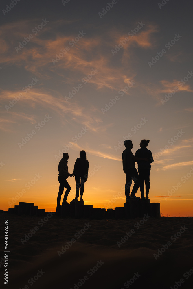 group of people at sunset against sky. sunset walk on seashore, nature background. joke and fun, relationships and carefree communication