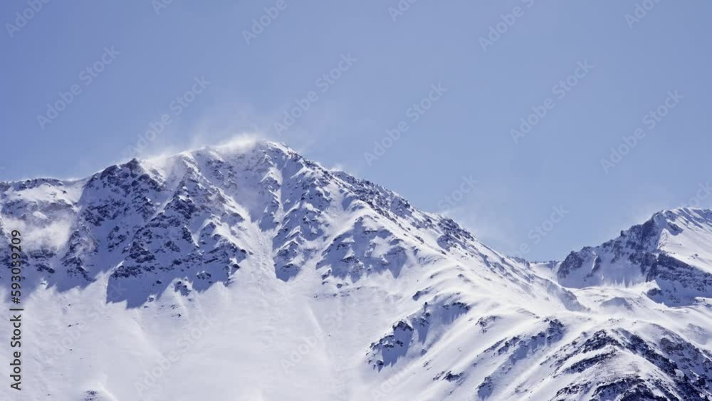 Snowy mountains with snow creating spirals in the air due to the wind. Embalse El Yeso. Snowy mountains with snow creating spirals in the air due to the wind. Embalse El Yeso.