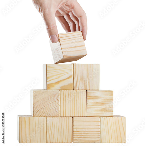 Hand putting a wooden cube on top of pyramid of cubes, cut out