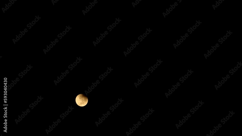 Breathtaking view of the full moon glowing yellow-brown in a starless sky on a pitch-black night Breathtaking view of the full moon glowing yellow-brown in a starless sky on a pitch-black night