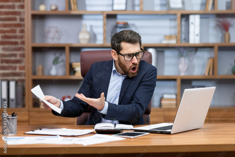 Obraz premium Angry shouting boss talking on video call with colleagues subordinates, man showing laptop document unsatisfactory report to camera, businessman mature adult in business suit working inside office.
