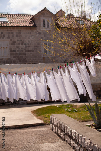 Fresh clean white clothing hanging outside in wind and sun to dry. Laundry drying on the rope outside on a sunny day near the sea.