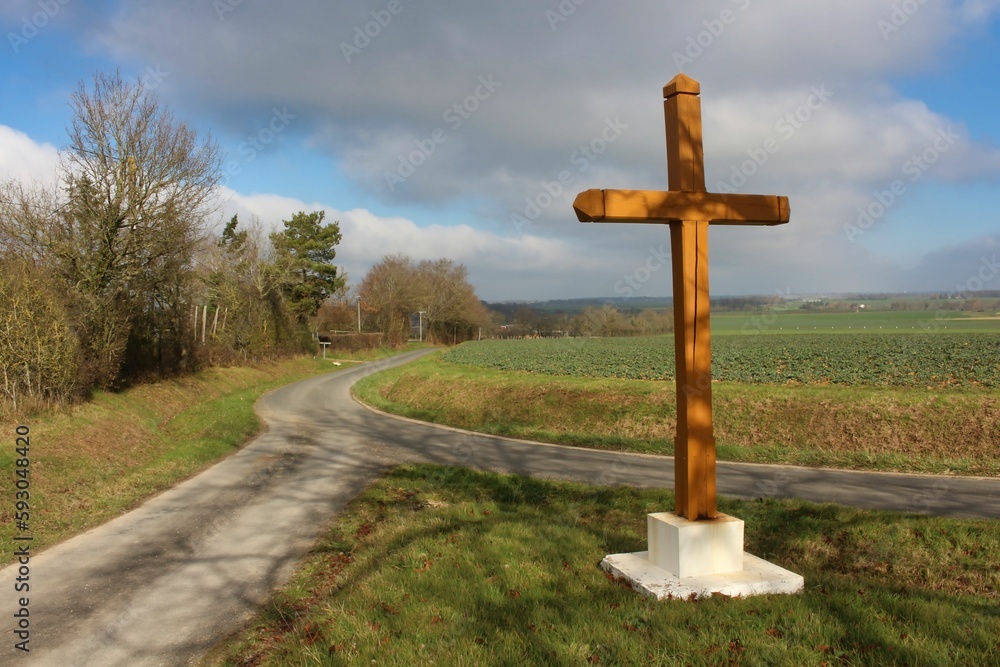 Croix en bois sur une intersection de routes de campagne avec ciel nuageux 