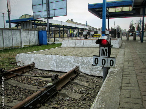 Near a dead end on the railway, a red traffic light is constantly on