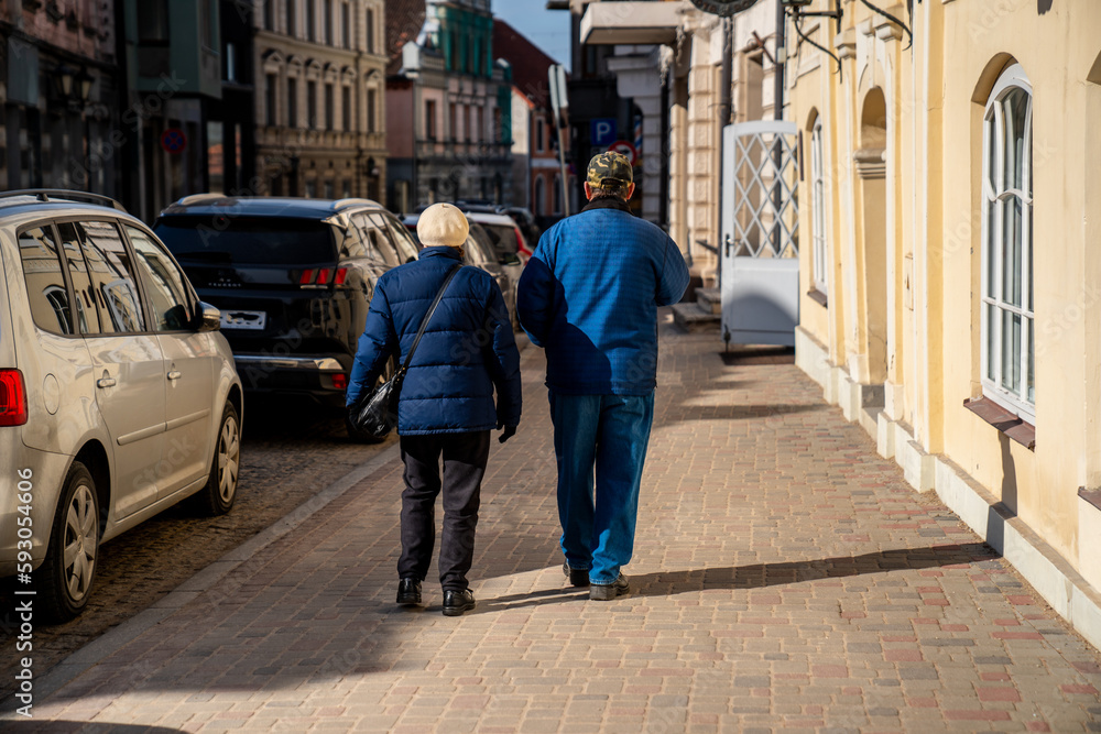 Older couple walking down the street in old town Cesis, Latvia Older couple walking down the street in old town Cesis, Latvia