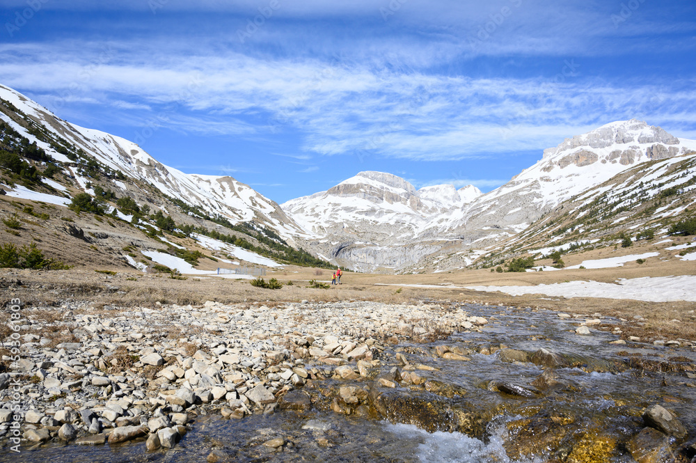 river crosses valley in the mountains in winter and the snow-capped mountains of the pyrenees