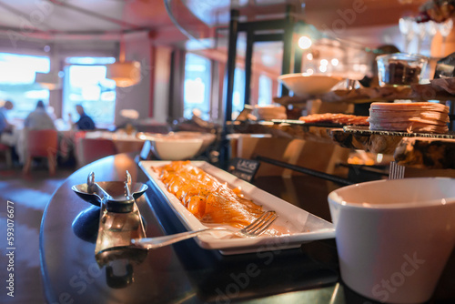 Closeup of salmon served in plate with fork on table in modern restaurant at luxurious hotel, luxury travel concept for tourists