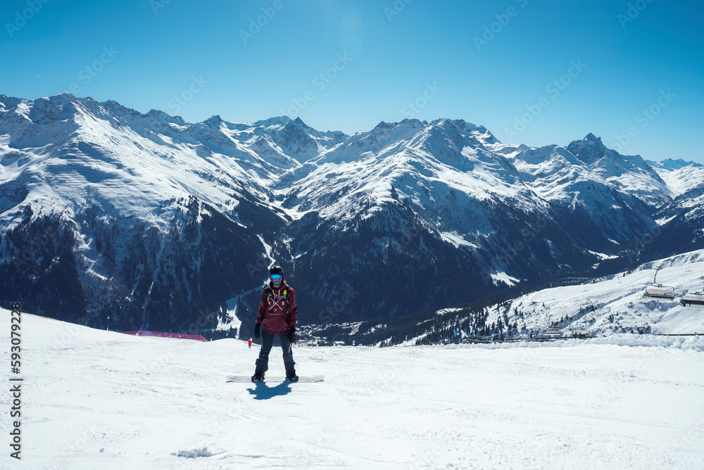 Tourist with snowboard on snow covered mountain with beautiful landscape and sky in background during vacation, winter holiday travel concept