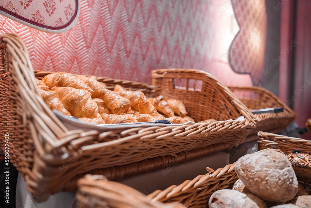 Closeup of freshly made croissants in wicker basket displayed at restaurant in luxurious tourist resort, luxury travel concept for tourists