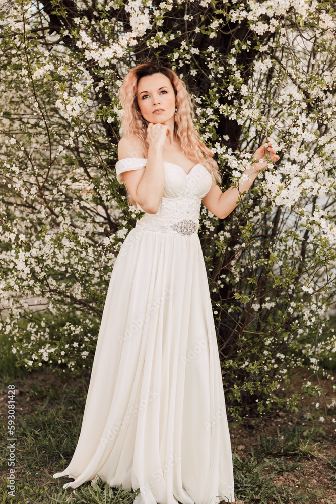 A beautiful bride near a cherry blossom. Spring Wedding