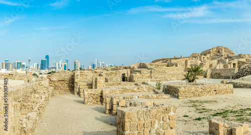 Ruins of Qalat al-Bahrain portuguese fortress with downtown in the background, Manama, Bahrain