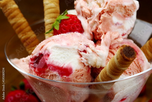 Primo piano di coppa di gelato al mandecato alla fragola con fragolee cannoli di wafer al coioccolato photo