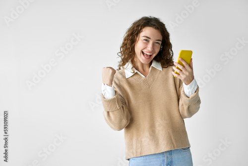 Young happy excited pretty woman student feeling winner holding cellphone using mobile phone winning game app prize, receiving great job offer celebrating standing isolated at white background.