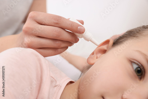 Mother dripping medication into daughter's ear, closeup © New Africa