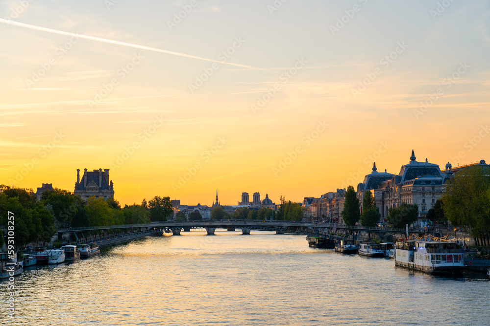 Seine river at sunrise overlooking Passerelle Leopold Sedar Senghor footbridge and rooftop of Notre  Dame cathedral in Paris. France