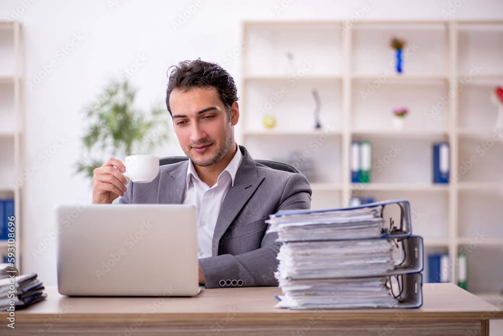Young male employee and too much work in the office Young male employee and too much work in the office