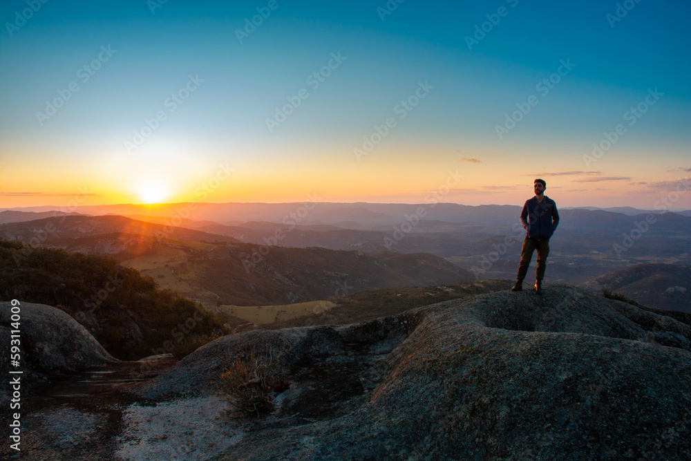 Silhouette of a person on top of the mountain under a beautiful summer sunset