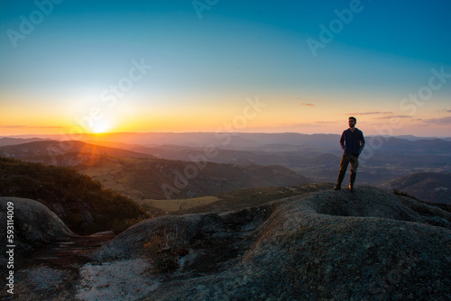Silhouette of a person on top of the mountain under a beautiful summer sunset © lifephotos