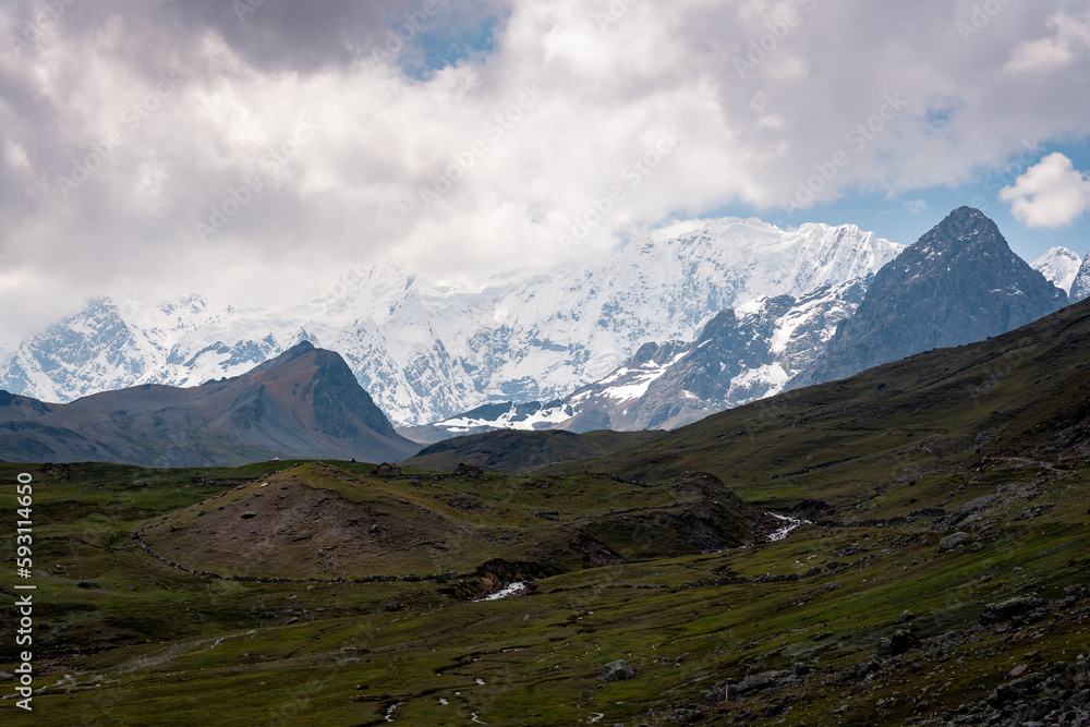 Young hikers on the ausangate circuit in front of the snow-covered peak, Ausangate 6384m, Cordillera Vilcanota, Peru, South America