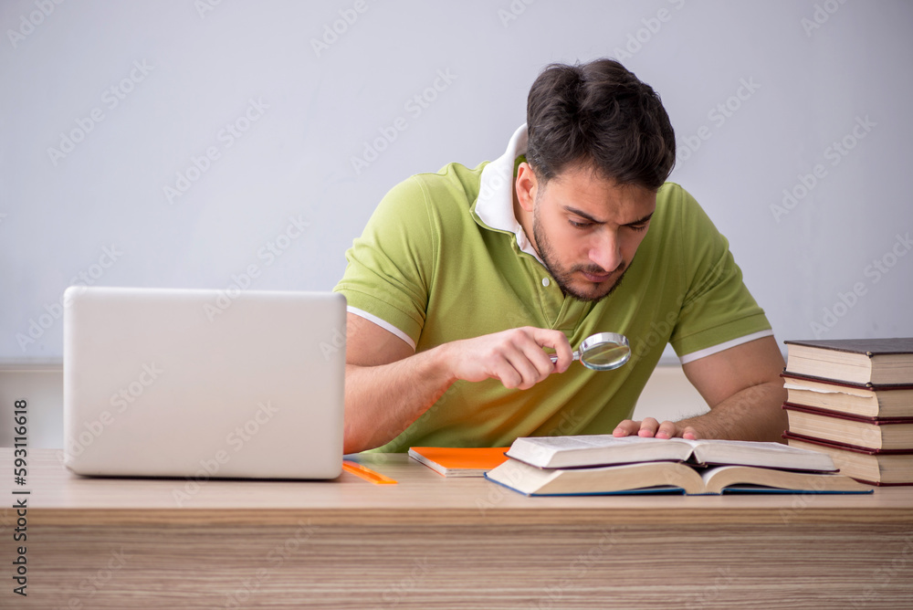 Young male student sitting in front of whiteboard Young male student sitting in front of whiteboard