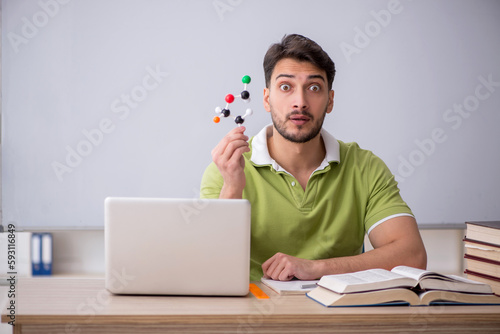Young male student physicist sitting in the classroom