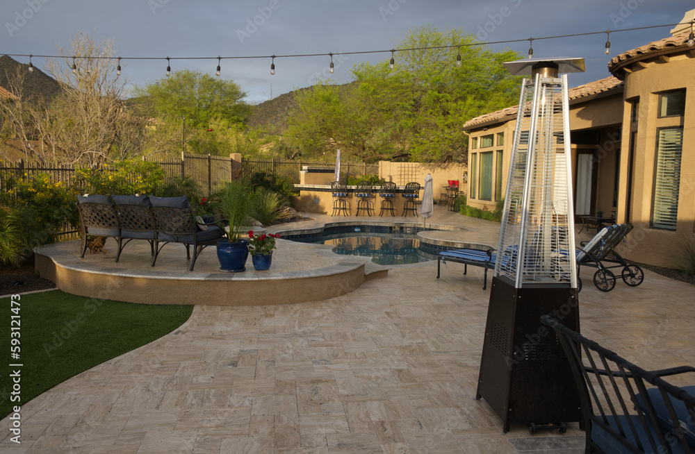 A desert landscaped backyard in Arizona featuring
a travertine tiled pool deck with spa and outdoor kitchen. A desert landscaped backyard in Arizona featuring
a travertine tiled pool deck with spa and outdoor kitchen.