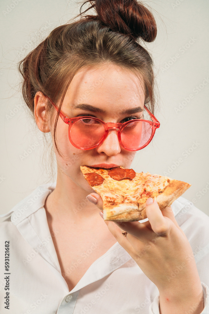 woman with glasses holding a piece of pizza