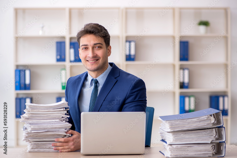 Young male employee and too much work in the office Young male employee and too much work in the office