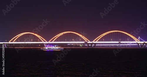 night view of a boat and cable-stayed bridge over Xiangjiang River, Furong district, Changsha, Hunan, China.