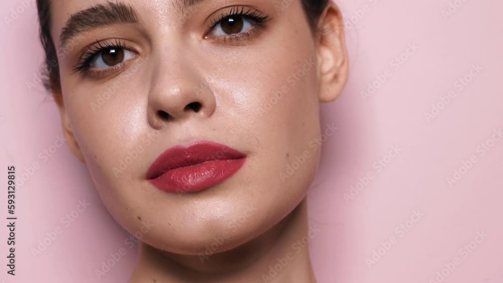 Fashion beauty portrait of young brunette woman with evening stylish makeup and perfect clean skin. Sexy model with hair in a bun posing in studio near wall. With pink bright natural lips Fashion beauty portrait of young brunette woman with evening stylish makeup and perfect clean skin. Sexy model with hair in a bun posing in studio near wall. With pink bright natural lips