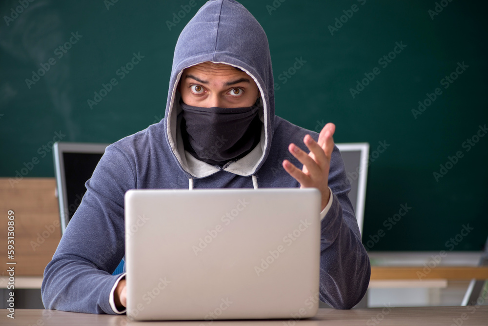 Young male hacker sitting in the classroom Young male hacker sitting in the classroom