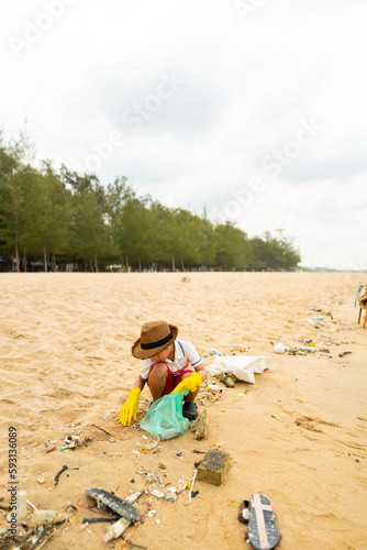 Happy Asian family travel ocean on summer holiday vacation. Little boy picking up plastic bottle and garbage on the beach in sunny day. Environmental conservation earth day and waste pollution concept