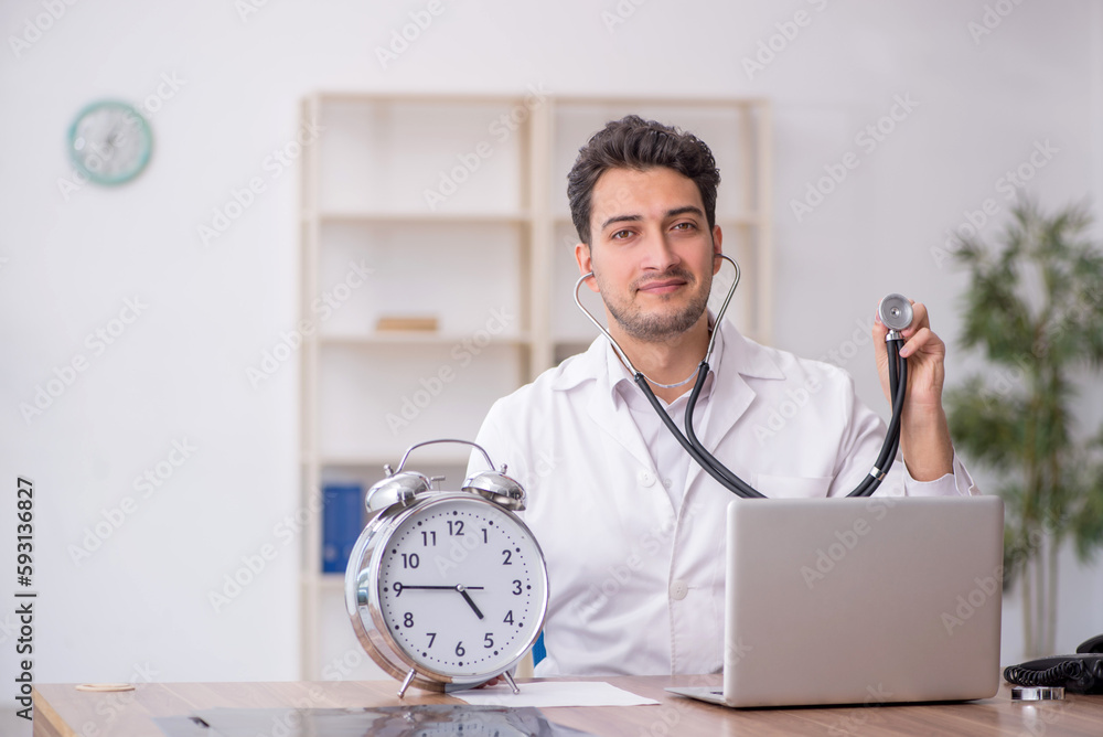 Young male doctor in time management concept Young male doctor in time management concept