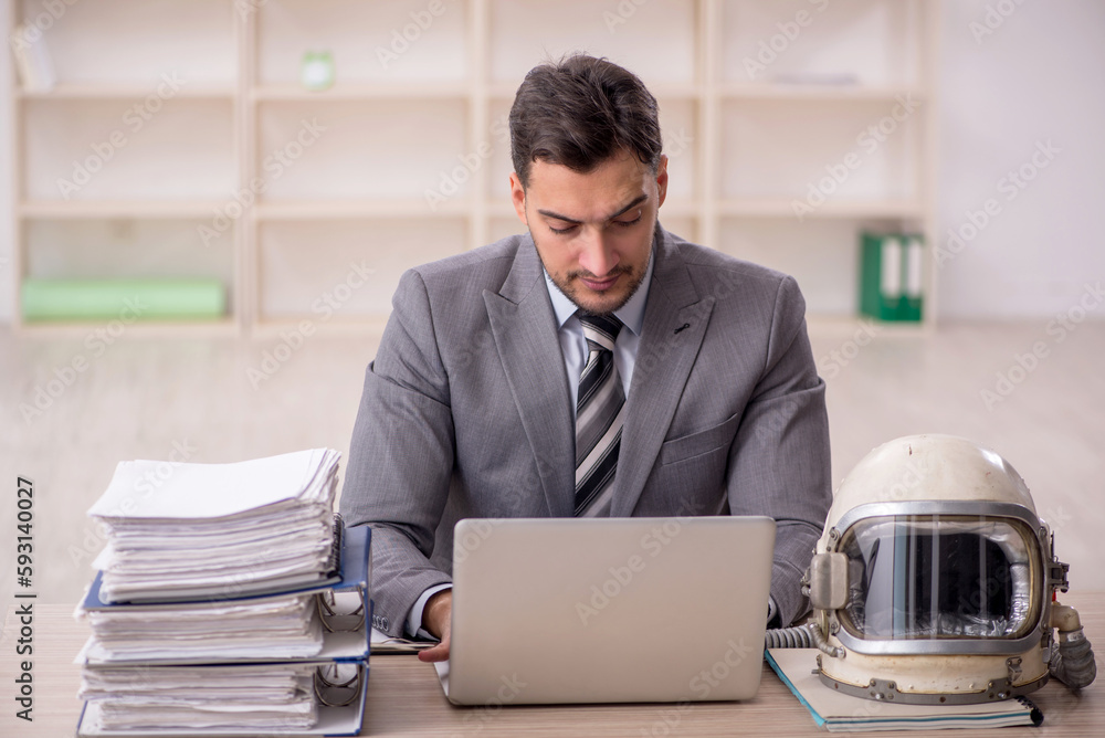 Young male employee wearing spacesuit in the office Young male employee wearing spacesuit in the office