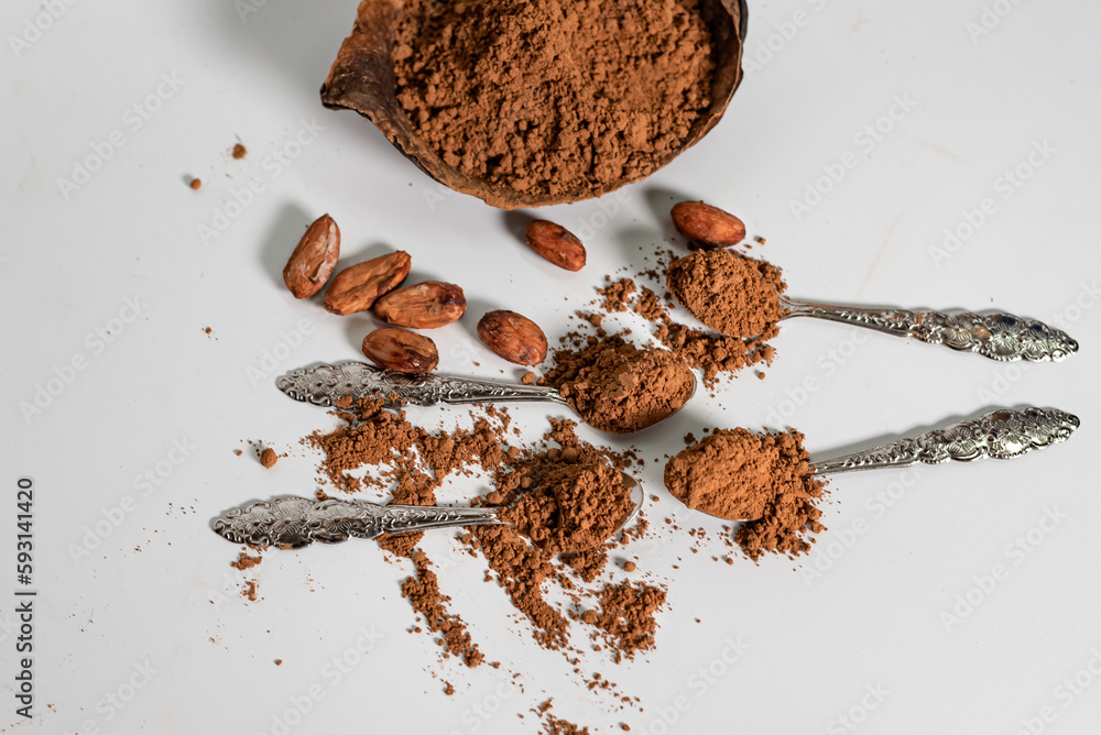 cocoa powder and cocao beans on white table.
