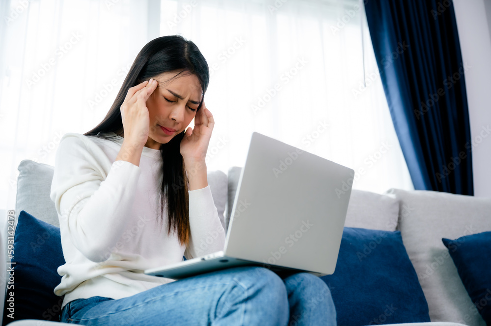 Office syndrome. Overworked tired young asian woman feeling headache, having eyesight problem after computer laptop work. Stressed young woman suffering from fatigue at home Office syndrome. Overworked tired young asian woman feeling headache, having eyesight problem after computer laptop work. Stressed young woman suffering from fatigue at home