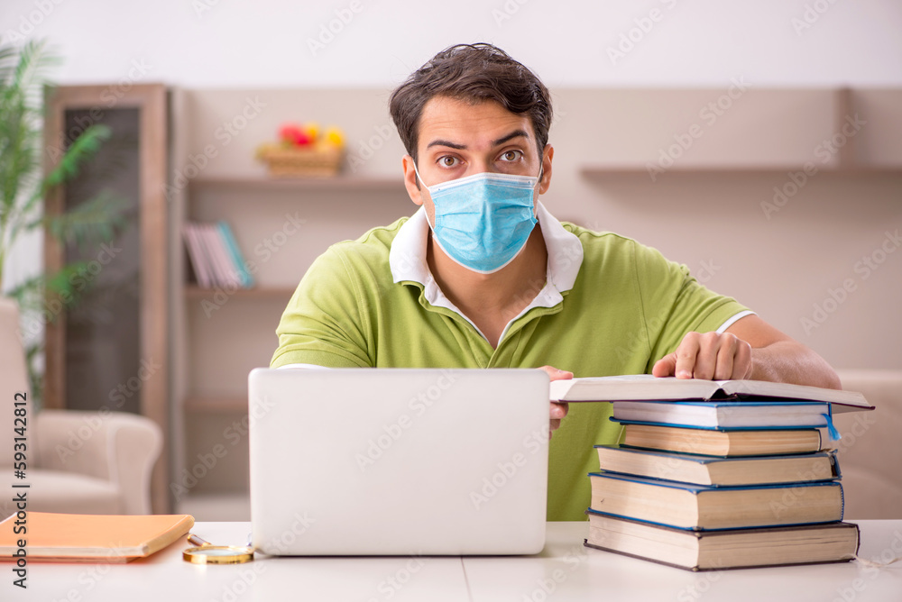Young male student preparing for exams at home during pandemic Young male student preparing for exams at home during pandemic