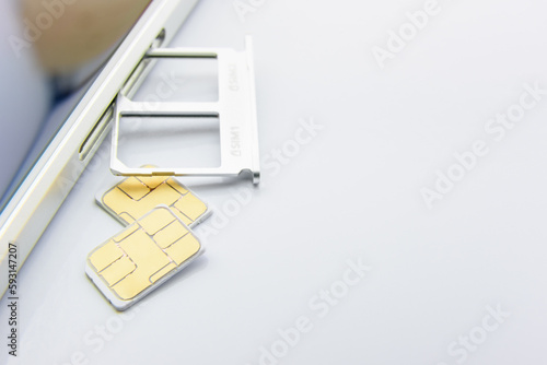 Broadband 5G mobile communication technology concept : SIM card tray / dual SIM card slot with two nano SIM cards on white background. SIM stores international mobile subscriber identity IMSI number. photo