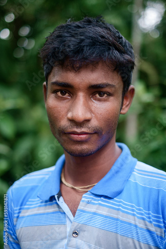 Portrait of a south asian young black village boy standing within nature 