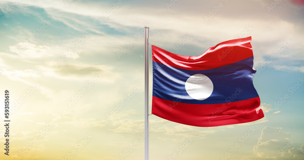 Laos national flag waving in beautiful sky. The symbol of the state on wavy silk fabric.