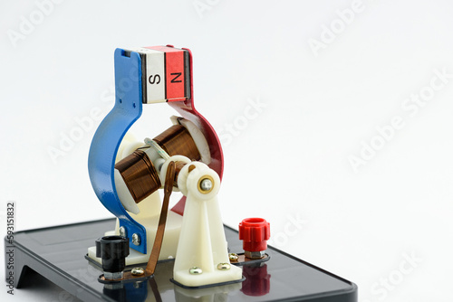 Experimental electric generator on white background, consists of copper coils and magnets. A generator is a device that converts mechanical energy to electrical energy for use in an external circuit.